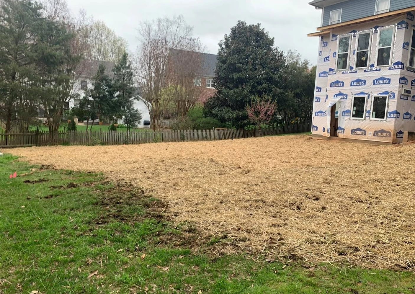 Freshly graded yard seeded and covered in straw
