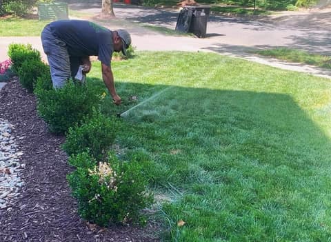 Crew member adjusting a sprinkler head while the zone runs