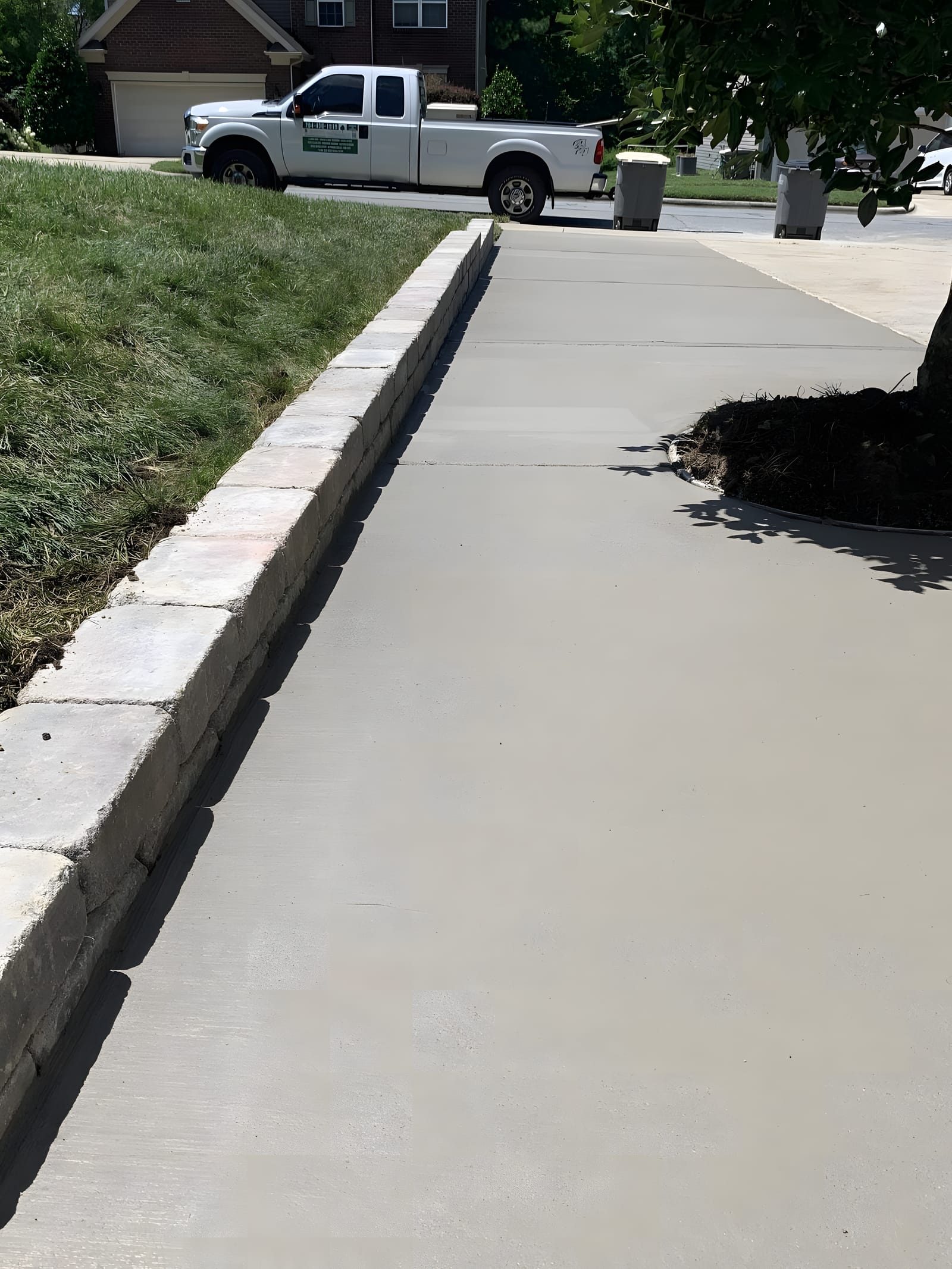 Freshly finished concrete walkway beside a lawn