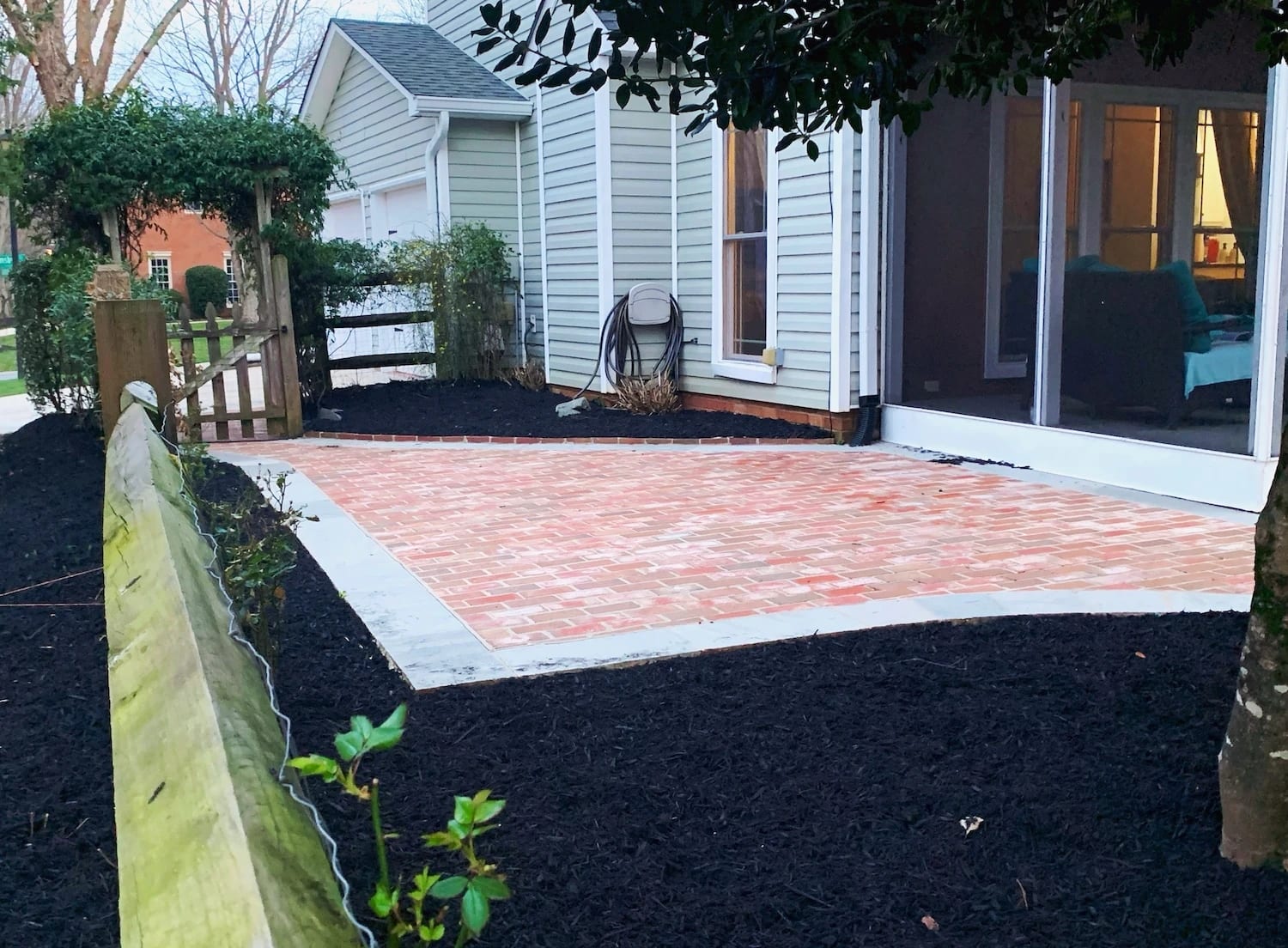 Classic brick patio and walkway bordered in bluestone with fresh mulch beds