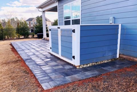 Custom trash can enclosure matched to the house siding on a new paver pad