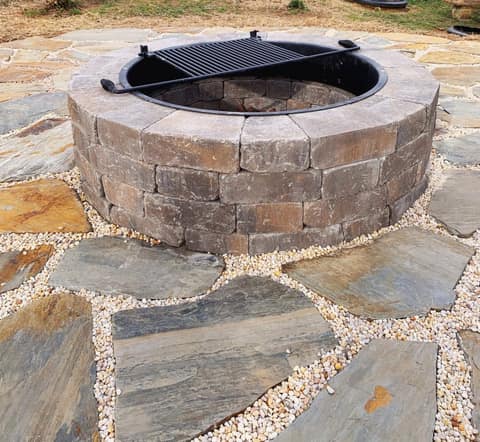 Stone fire pit detail on a paver patio