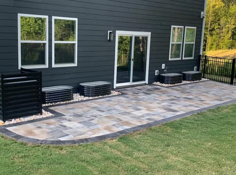 Multi-tone paver patio with a charcoal border along the back of the house